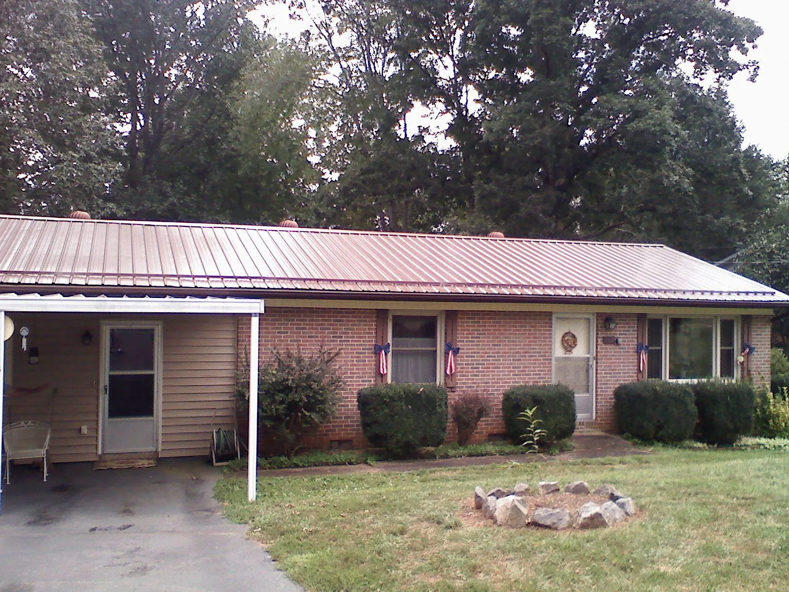 Bronze metal roof and carport on a brick ranch home — Roof Repair work by our crew in Hinton
