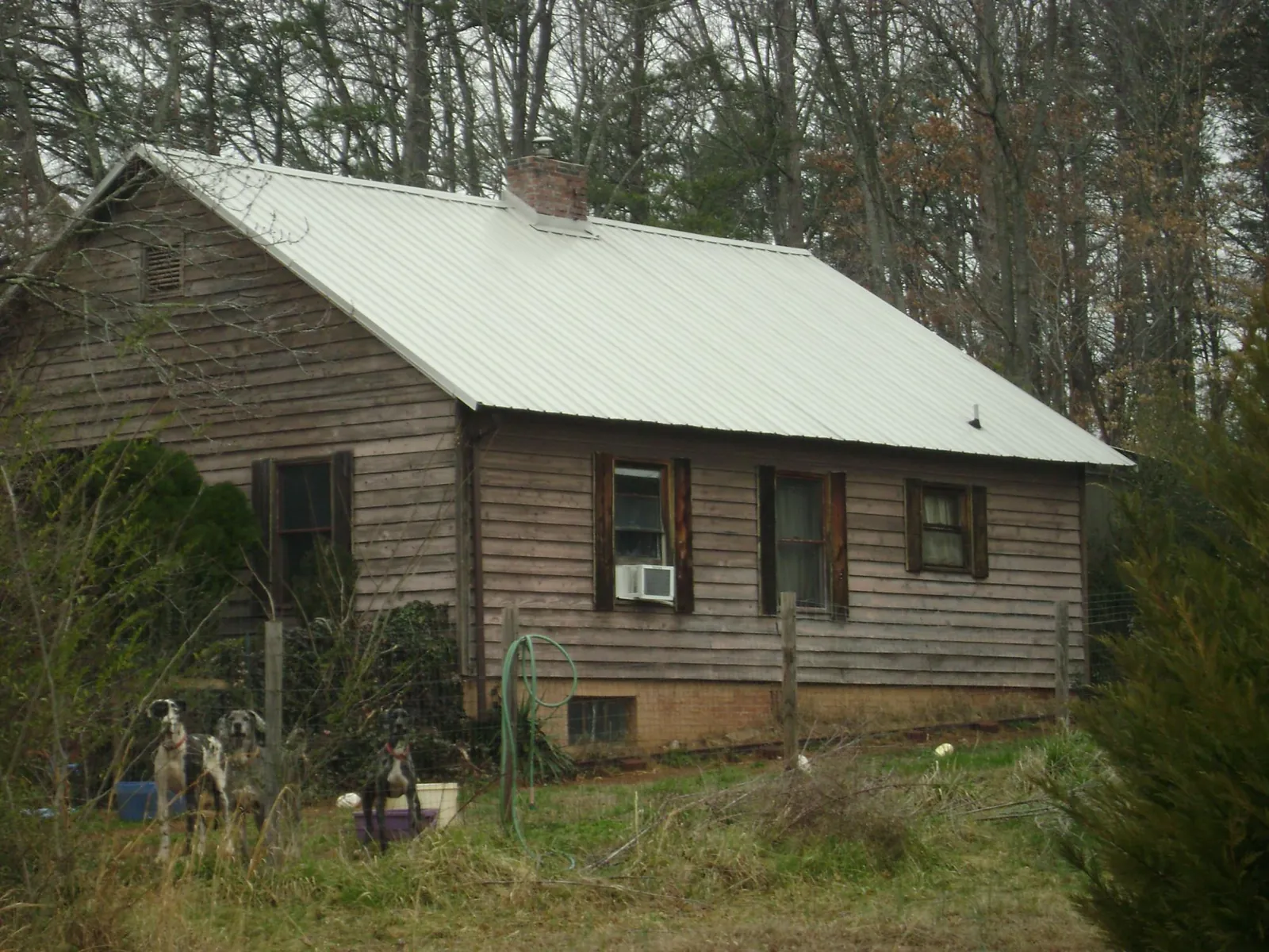 White metal roof on an old wood sided farmhouse, from a Metal Roof Installation job in Hinton